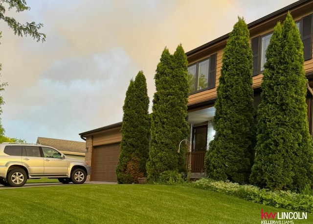 view of front facade with a front yard, concrete driveway, and a garage