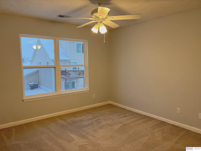 unfurnished room with ceiling fan and carpet