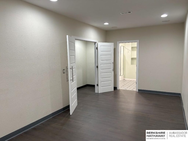 unfurnished room with dark wood-type flooring