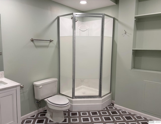 bathroom with vanity, a shower with shower door, and toilet