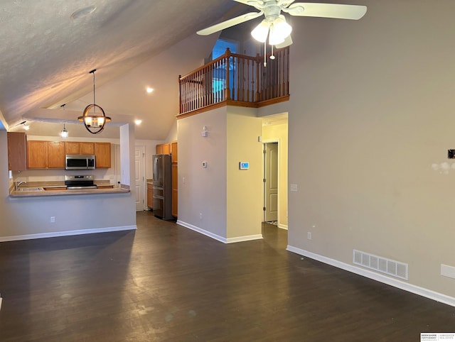 kitchen featuring appliances with stainless steel finishes, ceiling fan with notable chandelier, dark hardwood / wood-style flooring, and kitchen peninsula