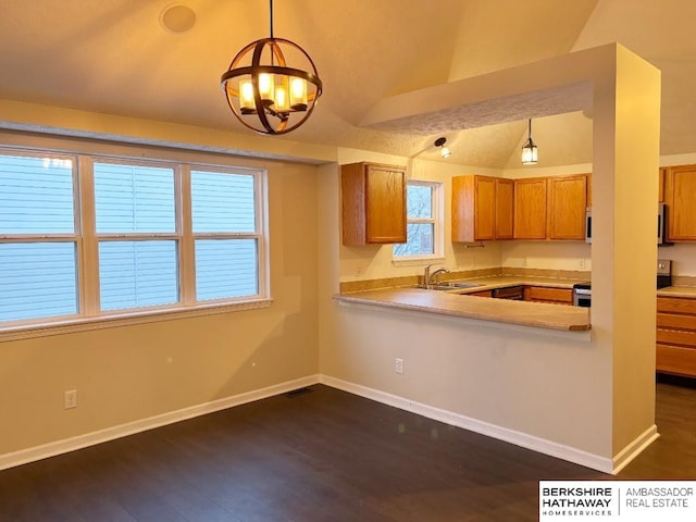 kitchen with vaulted ceiling, sink, dark hardwood / wood-style flooring, hanging light fixtures, and kitchen peninsula