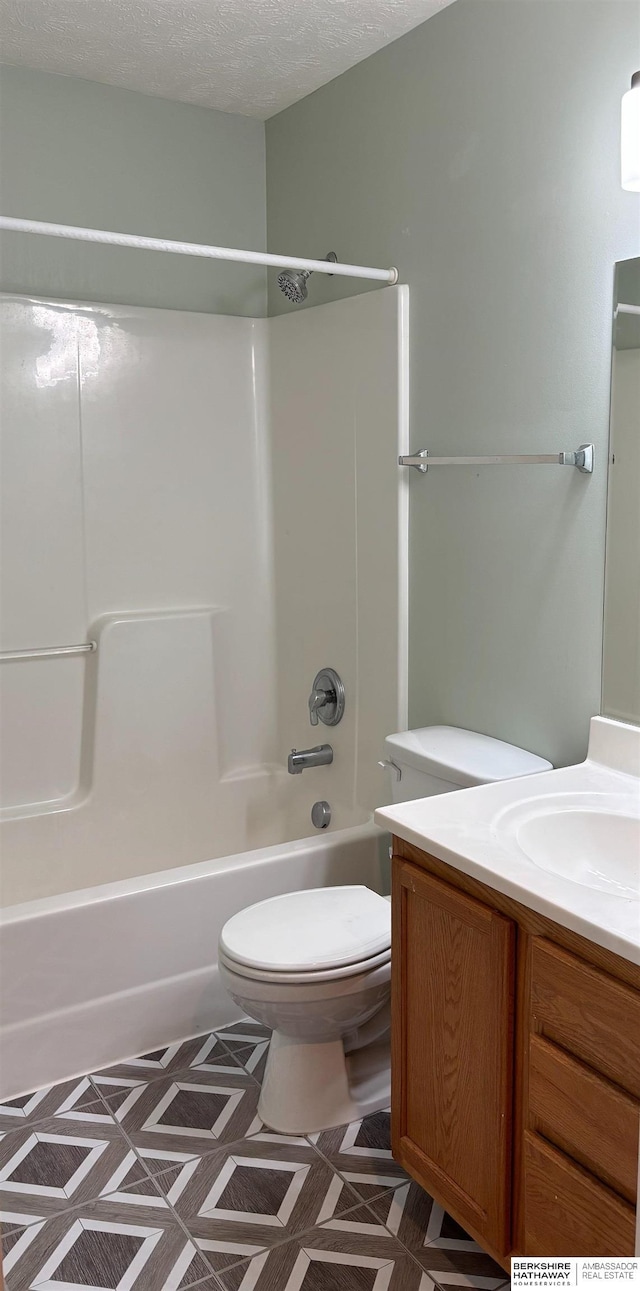 full bathroom featuring bathtub / shower combination, vanity, toilet, and a textured ceiling