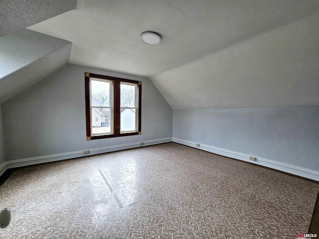 bonus room with vaulted ceiling and a textured ceiling