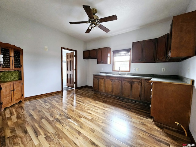 kitchen with ceiling fan, sink, light hardwood / wood-style floors, and dark brown cabinets