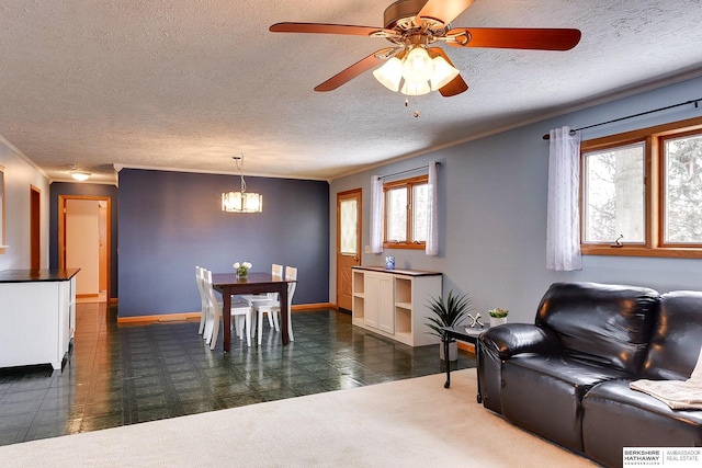 living room featuring a textured ceiling, ornamental molding, and ceiling fan with notable chandelier