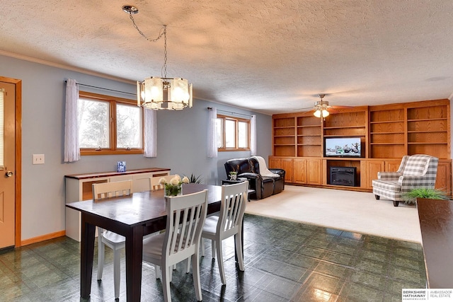 carpeted dining room featuring ceiling fan with notable chandelier and a textured ceiling