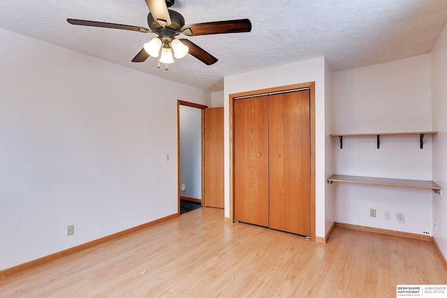 unfurnished bedroom featuring light wood-type flooring, a closet, ceiling fan, and a textured ceiling