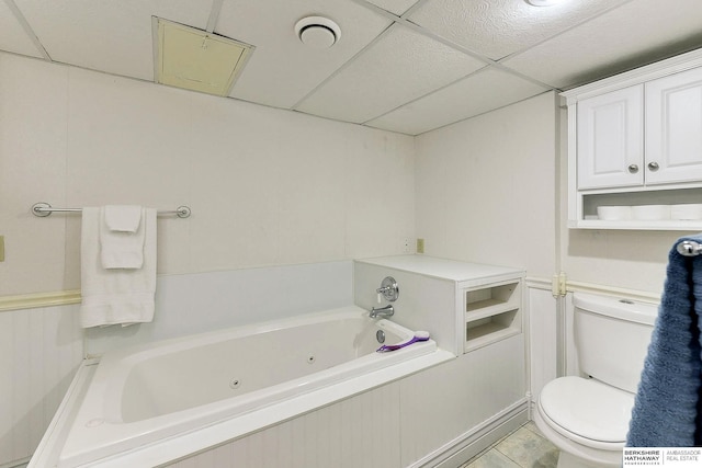 bathroom with a paneled ceiling, toilet, a washtub, and tile patterned floors