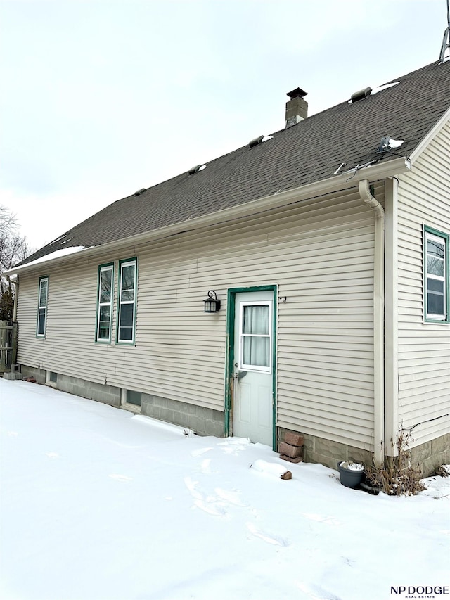 snow covered house featuring central air condition unit