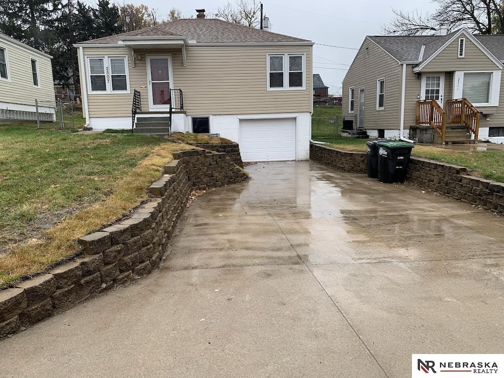 view of front of house featuring a garage and a front lawn