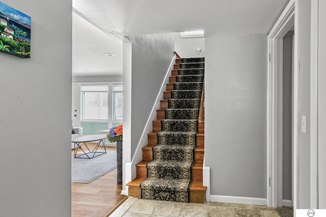 stairs featuring baseboards and wood finished floors