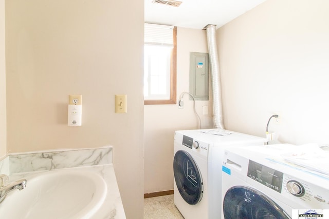 washroom with sink, electric panel, and washer and clothes dryer