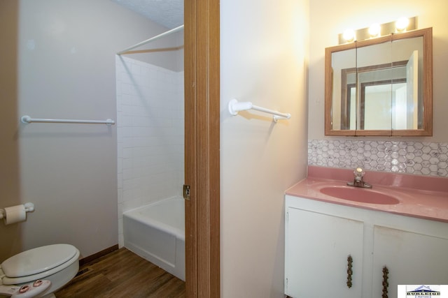full bathroom featuring toilet, hardwood / wood-style flooring, shower / bath combination, and vanity