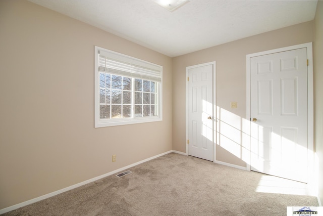 unfurnished bedroom featuring light carpet