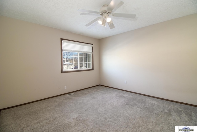 carpeted spare room with ceiling fan and a textured ceiling