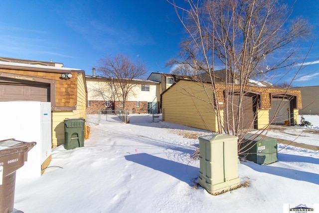 snow covered patio with a garage