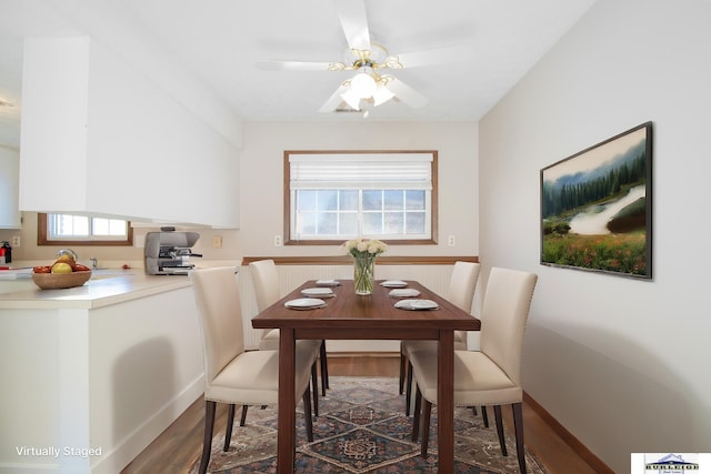 dining space with dark hardwood / wood-style flooring and ceiling fan