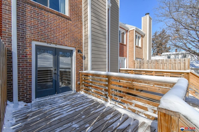 snow covered deck featuring french doors