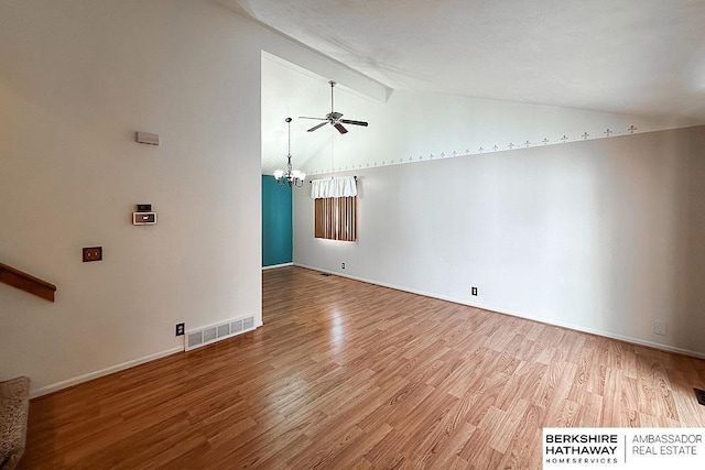 interior space featuring ceiling fan with notable chandelier, light hardwood / wood-style flooring, and lofted ceiling with beams