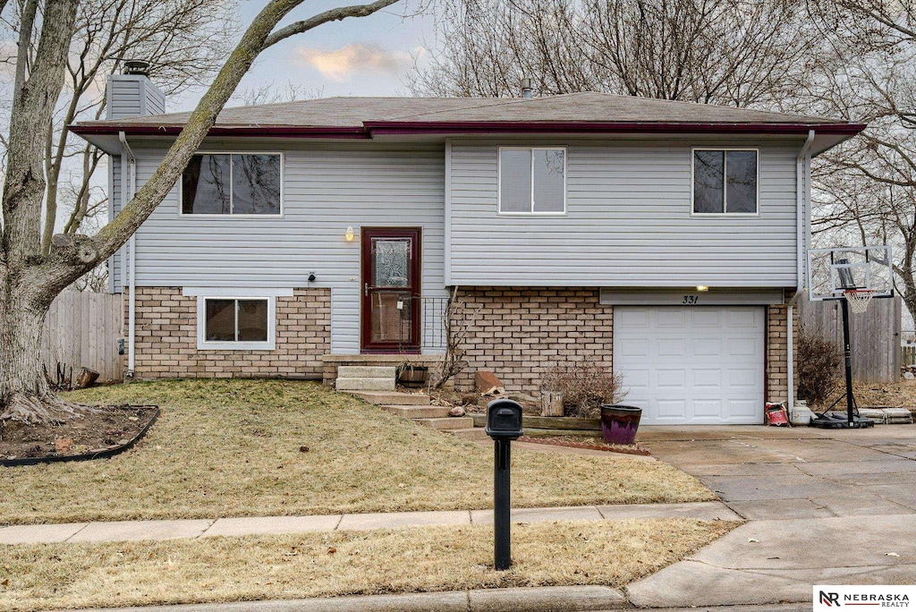 split foyer home with a garage and a front lawn