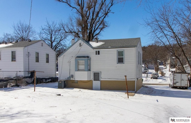 snow covered rear of property with central air condition unit