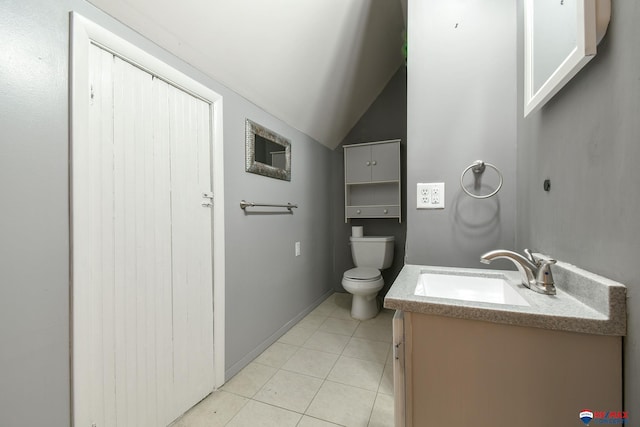 bathroom with tile patterned floors, lofted ceiling, vanity, and toilet