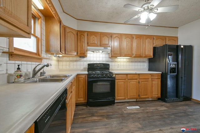 kitchen featuring black appliances, sink, a textured ceiling, dark wood-type flooring, and decorative backsplash