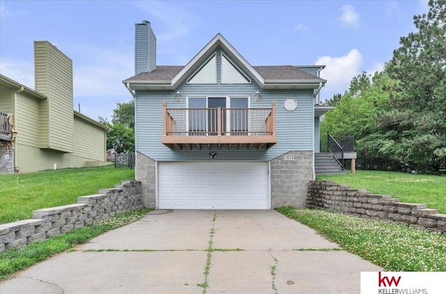 rear view of house featuring driveway, a garage, a balcony, a chimney, and a yard