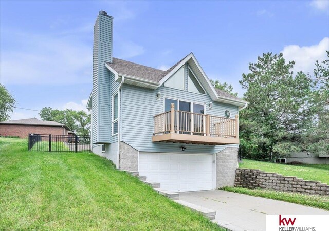 back of house with a yard, a chimney, concrete driveway, an attached garage, and fence