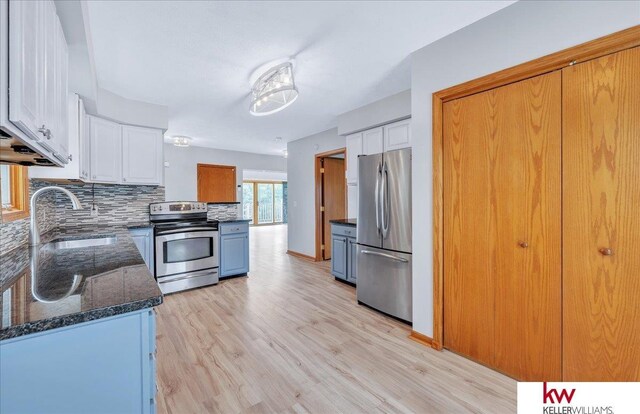 kitchen featuring white cabinets, appliances with stainless steel finishes, backsplash, and a sink