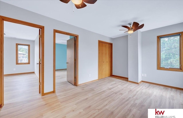 spare room with a ceiling fan, light wood-type flooring, and baseboards