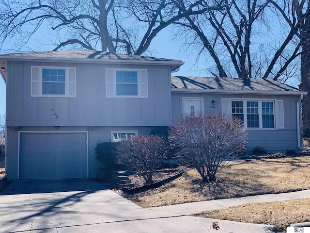 split level home with aphalt driveway, board and batten siding, and an attached garage