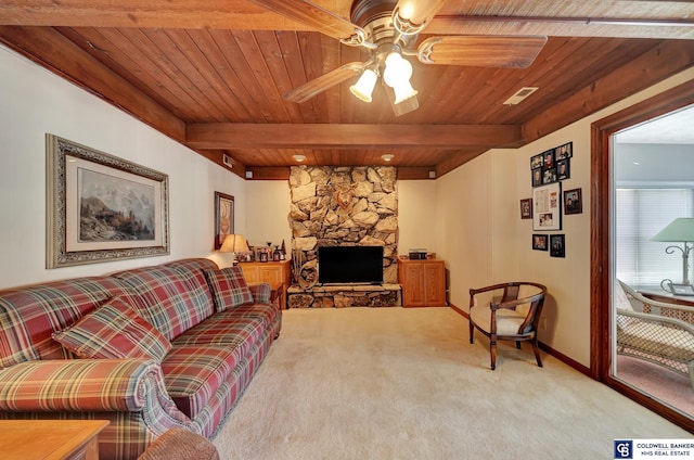 carpeted living room with ceiling fan, beamed ceiling, wooden ceiling, and a fireplace