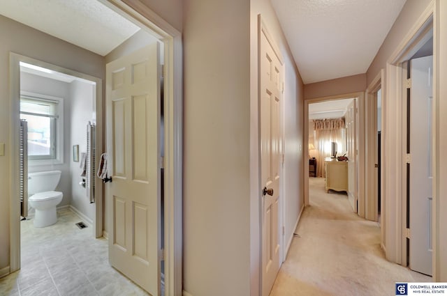 hallway with a textured ceiling