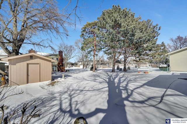 yard layered in snow with a shed