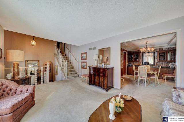 living room featuring a chandelier, a textured ceiling, and light colored carpet