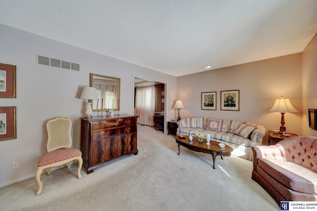 living room with a textured ceiling and light carpet