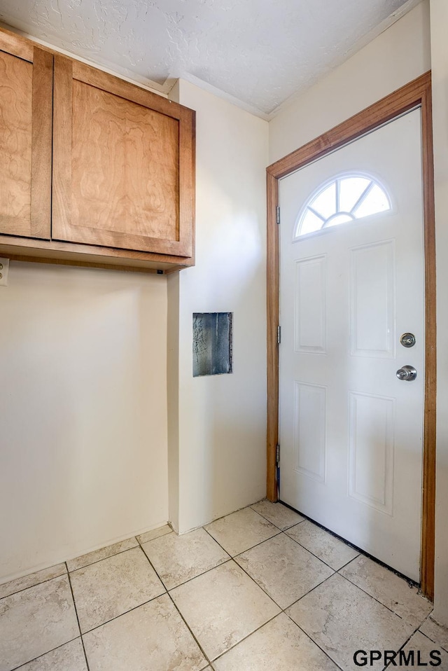 entrance foyer featuring a textured ceiling and light tile patterned flooring