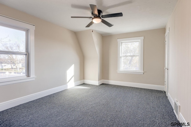 unfurnished room featuring ceiling fan and dark colored carpet