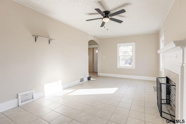 unfurnished living room with ceiling fan, light tile patterned floors, crown molding, and a textured ceiling