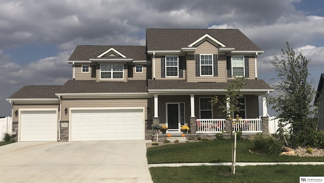 craftsman-style home with a garage, a front lawn, and a porch