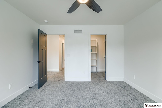 307 S 55th St, Lincoln, NE 68510 - unfurnished bedroom featuring carpet floors, baseboards, a walk in closet, and ceiling fan