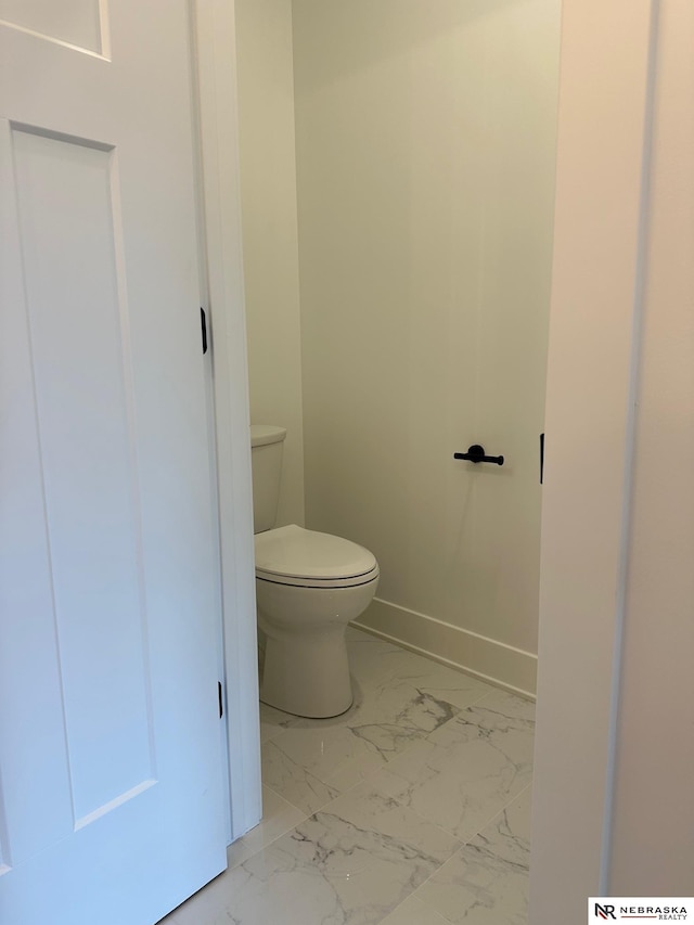 bathroom featuring marble finish floor, toilet, and baseboards