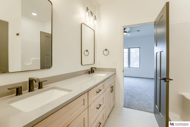 full bath featuring double vanity, a sink, and baseboards