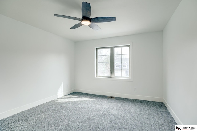 carpeted spare room with a ceiling fan, visible vents, and baseboards