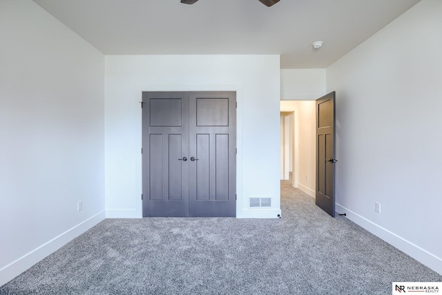 unfurnished bedroom featuring a closet, carpet flooring, visible vents, and baseboards