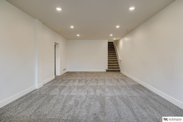 empty room featuring carpet, recessed lighting, visible vents, stairway, and baseboards