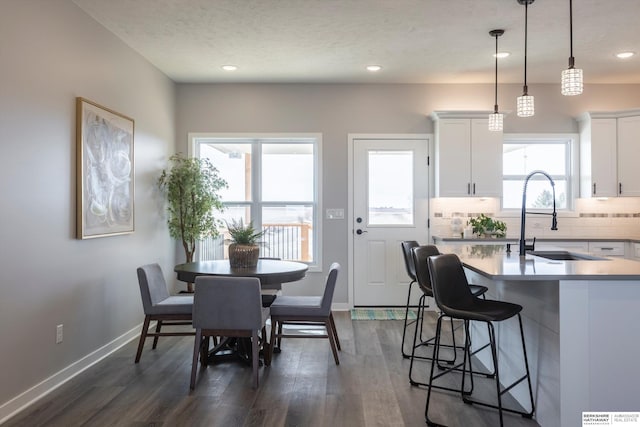 dining space featuring baseboards, dark wood finished floors, a textured ceiling, and recessed lighting