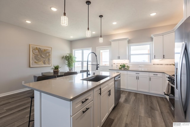 kitchen featuring stainless steel appliances, tasteful backsplash, plenty of natural light, and a sink